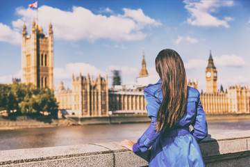 London Europe city autumn travel urban tourist woman in blue coat looking at Westminster and Thames river, famous tourism attraction landmark. Autumn season traveller people lifestyle. Wanderlust.