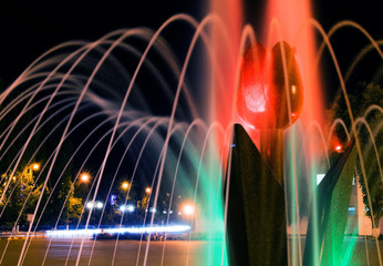 A close-up picture of beautiful illuminated city fountain A Tulip Flower at fall evening in Pokrov town in Ukraine, 2017