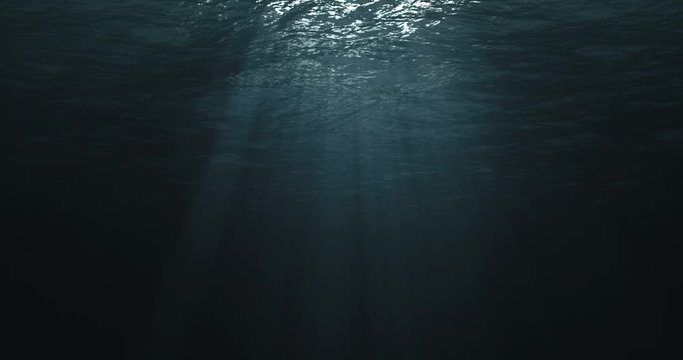 perfectly seamless loop of deep blue caribbean ocean waves from underwater background, light rays shining through