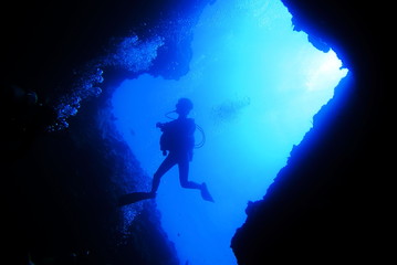 海底の洞窟内で泳ぐダイバー