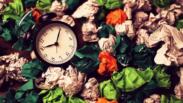 Alarm clock in a wastepaper concept for a time waste of time with cork board texture background