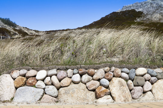 typical planted wall at sylt to protect the environment with natural grasses on top of the stone wall