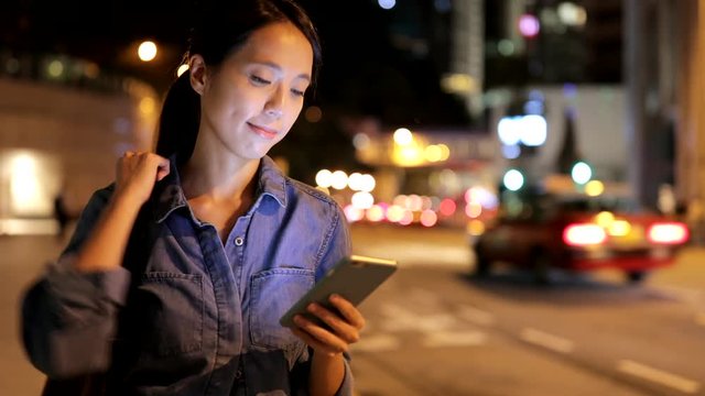 Woman use of taxi app on cellphone and waiting at outdoor