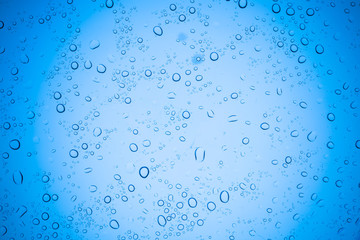 Rain droplets on blue glass background, Water drops on glass.