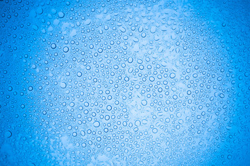 Rain droplets on blue glass background, Water drops on glass.