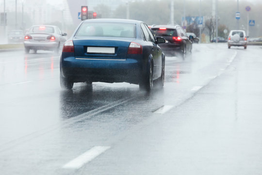 blurred image of cars on wet road through the windshield