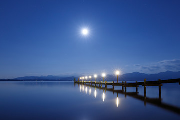 Fototapeta na wymiar Jetty at Full Moon at Lake Chiemsee with Alps in Background, Rosenheim, Bavaria, Germany, Long Time exposure, soft