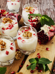 yogurt dessert with walnuts and pomegranate selective focus