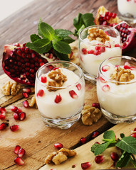 yogurt dessert with walnuts and pomegranate selective focus