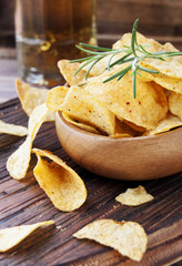 Chips in a wooden bowl and beer