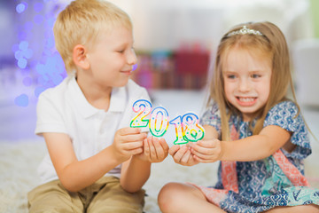 Obraz na płótnie Canvas Children boy and girl holding new year 2018