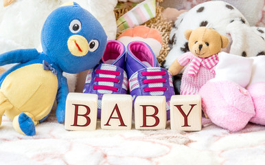Wooden cubes with word "BABY" and child toys.