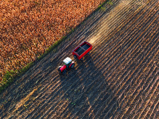 Obraz premium Farmer driving agricultural tractor and trailer full of grain