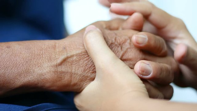 Hands of young woman holding and gentle touch to Hands of old women metaphor and concept for body language feeling love soothe and hope of family old mother and young daughter