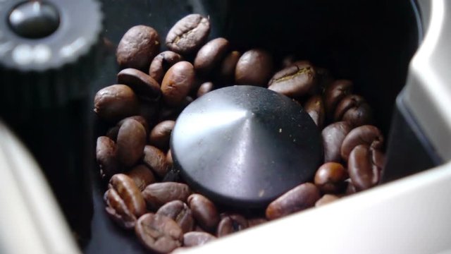 Slow motion ,coffee grains are milled in the coffee machine for preparation of fragrant coffee