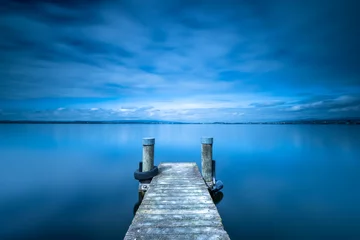Poster de jardin Jetée Overcast. Wooden pier. Lake to the horizon. Long exposure. 