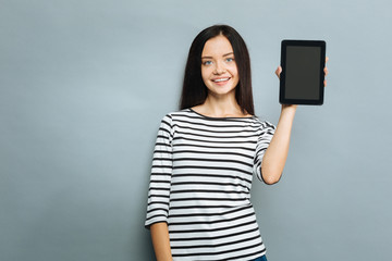 Naklejka premium Positive delighted young woman demonstrating her device