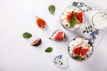 Eton Mess. Fresh figs with whipped cream and meringue in a glass beaker. Dessert.Meringue from egg whites. selective focus