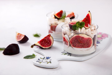 Eton Mess. Fresh figs with whipped cream and meringue in a glass beaker. Dessert.Meringue from egg whites. selective focus