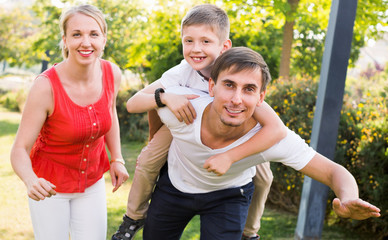 Portrait of cheerful family with boy sitting on father's back