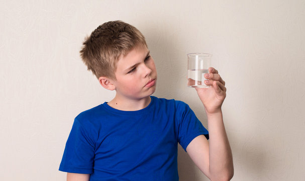 Kid observing a half full or half empty glass of water.