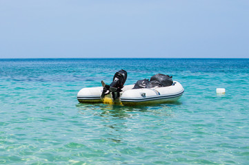 Inflatable dinghy boat with outboard motor moored in tropical sea