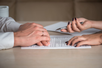 Hands of contractual parties, a woman and a man, signing a contract: business, premarital, loan, mortgage, credit, sales and purchase, investment agreement, divorce documents or other papers - 171021081