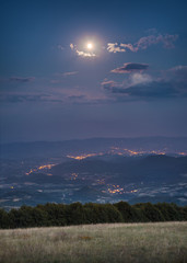 Beautiful landscape in full moon night with view on city