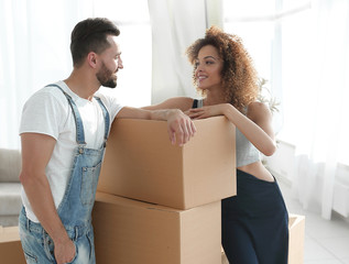 Loving couple standing next to boxes