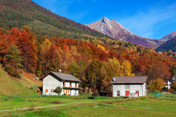Rural houses and autumnal mountains in Switzerland.