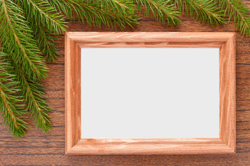 Wooden frame for photos and fir branches on the table