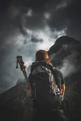 Papier Peint photo autocollant Alpinisme Mountain climber looking towards a stormy summit