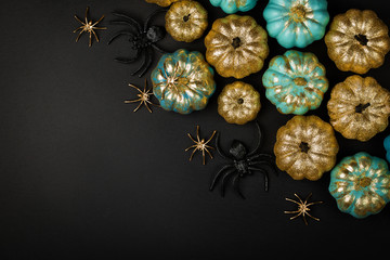 Shiny gold and blue Pumpkins with spiders. Halloween decorations. Trendy holiday concept.