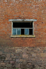 Fototapeta na wymiar The old brick wall with broken glass window as background
