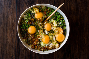 Raw ingredients eggs mixed with chives, onion, parlsey and pepper for Turkish Food Mucver Recipe