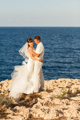 Bride and groom by the sea on their wedding day.