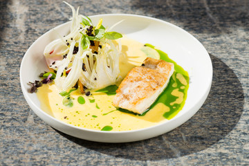 Fine dining, white fish fillet breaded in herbs and spice with shrimps and vegetables