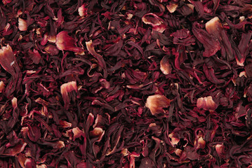 dry carcade  tea, creative texture background, red flowers of hibiscus - obrazy, fototapety, plakaty