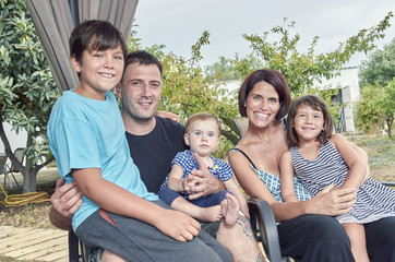 Big family. Parents with three children outdoors. Two daughters and one son.