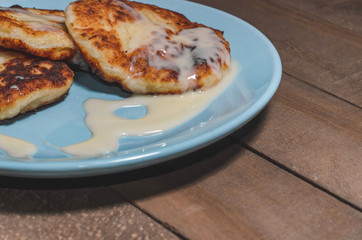 Appetizing sour cream with cream on a blue plate on a wooden dark background