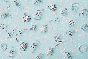 Stylish christmas background with confetti, serpentine and silver stars top view. Flat lay.