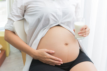 pregnant woman Holding a glass of fresh milk for healthcare