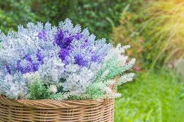 artificial flowers bouquet arrangement in wicker baskets at beatiful garden