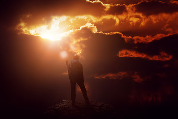 Silhouette eines Bergsteigers in feurigem Sonnenuntergang
