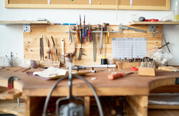 Background image of wooden workstation table in  workshop with tools for woodwork and metalwork on it