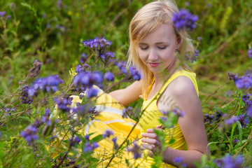 Girl in purple flowers outdoors in summer