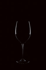 Mit Rotwein gefülltes Weinglas vor schwarzem Hintergrund