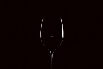 Mit Rotwein gefülltes Weinglas vor schwarzem Hintergrund