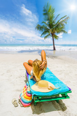 Woman sitting on a bed at the beach