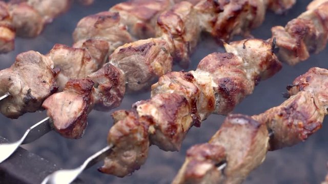 Grilling pork kebab on skewers at bbq, cooking process